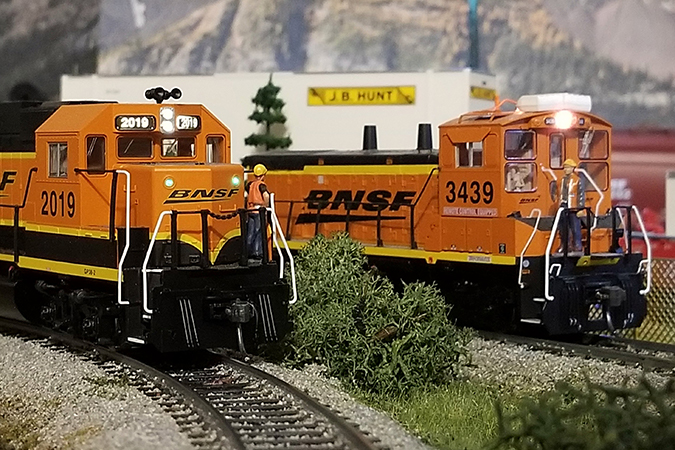 Crew members on two stopped locomotives have an impromptu meeting.
